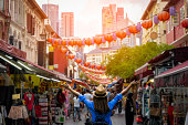 Young woman traveler with backpack and hat traveling into Chinatown at singapore city downtown. Travelling in Singapore concept