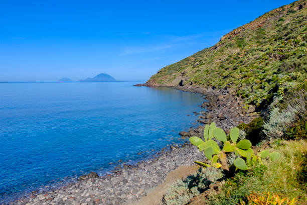 Beach of Pra' Venezia in Salina, the second largest island of the Aeolian archipelago. Alicudi and Filicudi in background. (Sicily, Italy) Beach of Pra' Venezia in Salina, the second largest island of the Aeolian archipelago. Alicudi and Filicudi in background. (Sicily, Italy) filicudi stock pictures, royalty-free photos & images