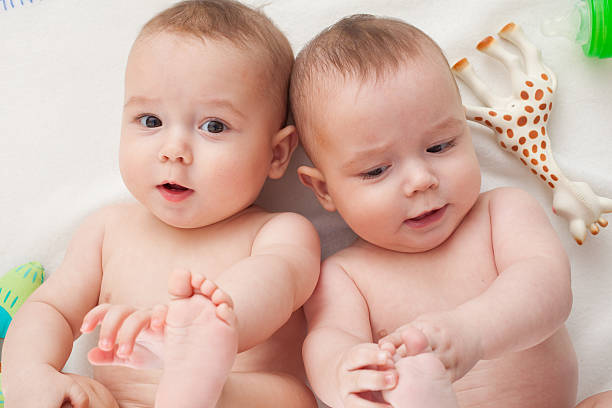 istock Baby twins touching their feet 98395055