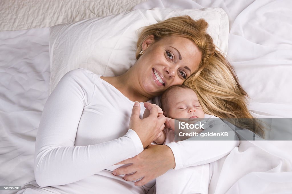 Madre con Bambino che dorme nel suo braccia - Foto stock royalty-free di 25-29 anni