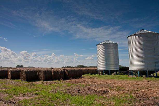 Silo and hay bale with big sky stock photo