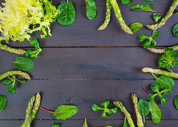 istock Fresh asparagus and green herbs on dark background. Top view 983966572