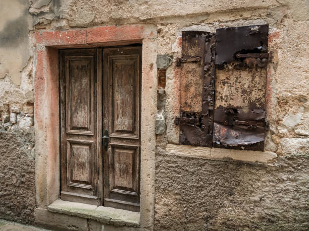 istock Weathered old door and window of a stone house 983967270