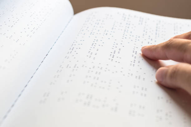 livro de braille para baixa visão / pessoa cega lendo braille sinal dedo tocando em relevo papel de textura para o dia mundial da visão e o conceito de consciência dia mundial de braille - eyesight senior adult care support - fotografias e filmes do acervo