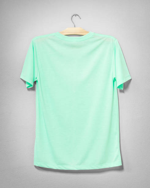 istock Green shirt hanging on cement wall. Empty clothing for design. Back view. 983999746