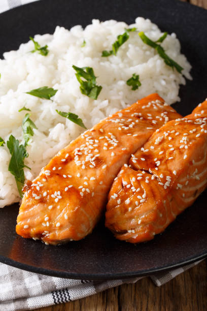 istock Glazed salmon fillet with rice garnish close-up. vertical 984003632