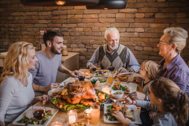 istock Happy extended family talking on Thanksgiving dinner at dining table. 984007382