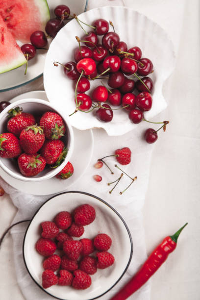 istock Red fruit and vegetable composition on linen fabric. Summer natural beauty concept with copy space. Vertical composition 984011450