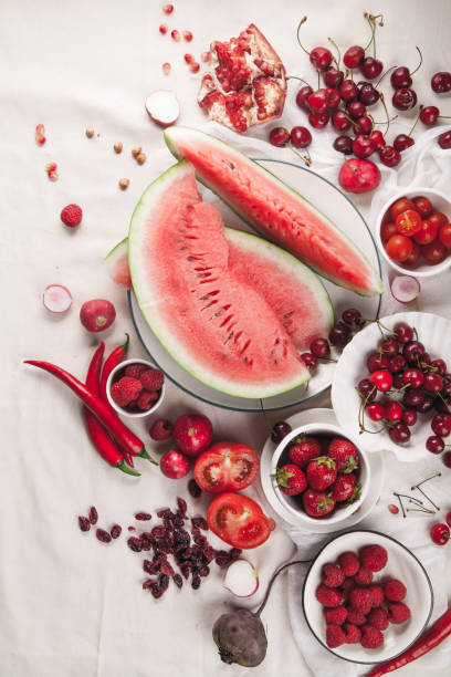 istock Red fruit and vegetable composition on linen fabric. Summer natural beauty concept with copy space. Vertical composition 984011470