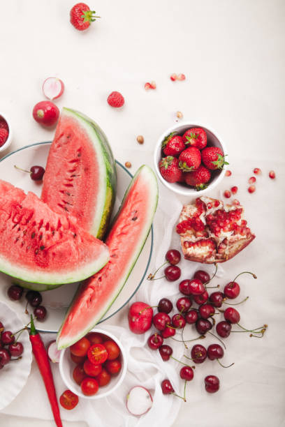 istock Red fruit and vegetable composition on linen fabric. Summer natural beauty concept with copy space. Vertical composition 984011526