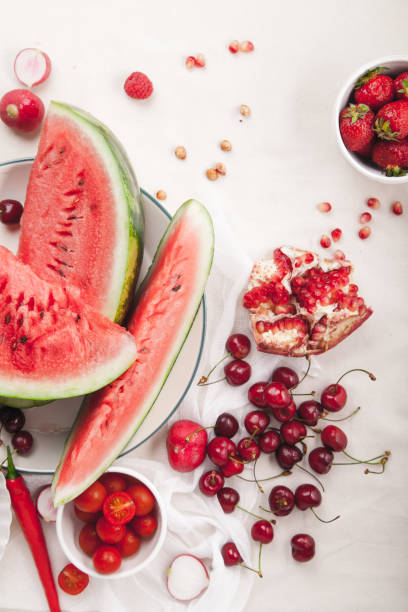 istock Red fruit and vegetable composition on linen fabric. Summer natural beauty concept with copy space. Vertical composition 984011532