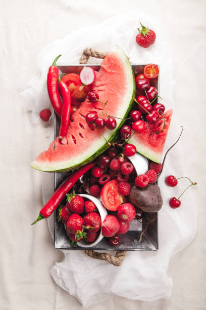 istock Red fruit and vegetable composition on metallic tray on linen fabric. Summer natural beauty concept with copy space. 984011600