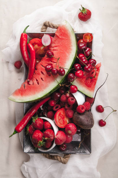 istock Red fruit and vegetable composition on metallic tray on linen fabric. Summer natural beauty concept with copy space. 984011612