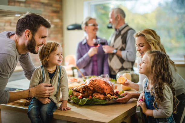 istock Happy family talking while about to have Thanksgiving dinner at home. 984012278