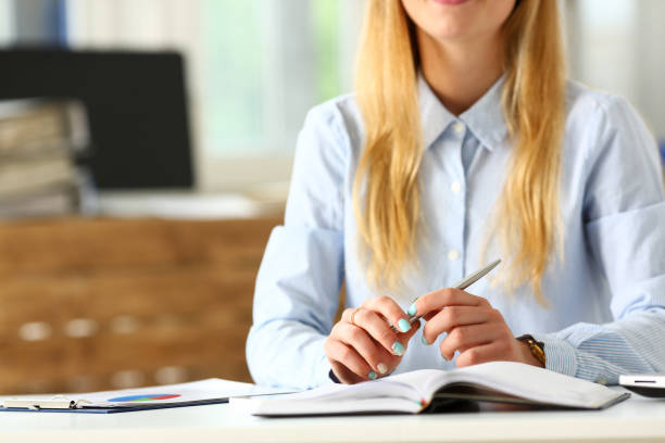 istock Female arm in suit hold silver pen making note 984018852