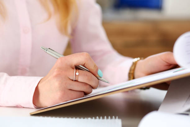 istock Female arms hold silver pen and pad 984018860