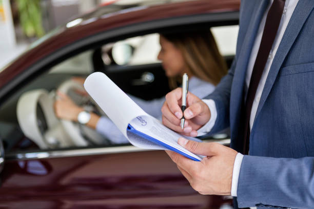 istock Salesman finishing contract document for car sale 984019054