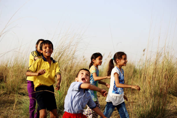 High-key image of two little girls playing at playground on last sunny day in autumn