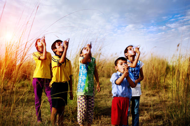 Photograph of some paper colorful planes on ready to fly on children hands