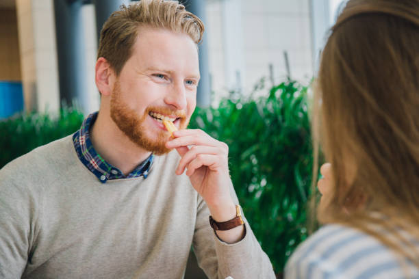istock Smiling man eating french fries 984023132