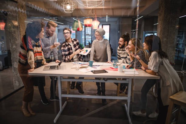 istock Group of happy business people talking while analyzing business chart in the office. 984023510