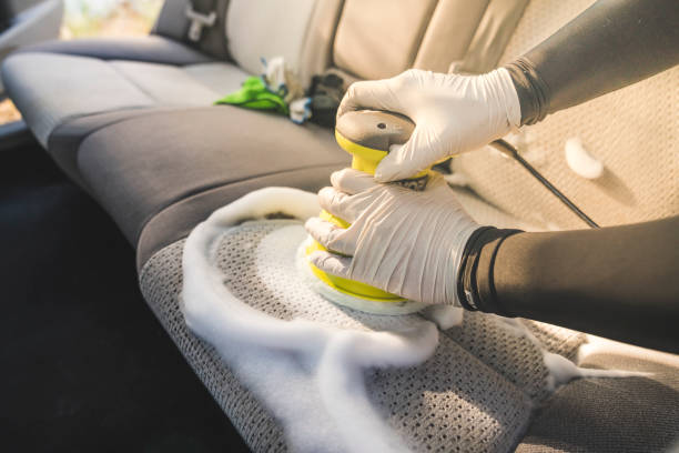 一個人用泡沫化學和洗滌機清洗汽車內飾。 - 嬰兒安全座椅 圖片 個照片及圖片檔