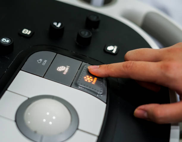 istock Doctor hand pressing on control panel button of ultrasound machine 984028688