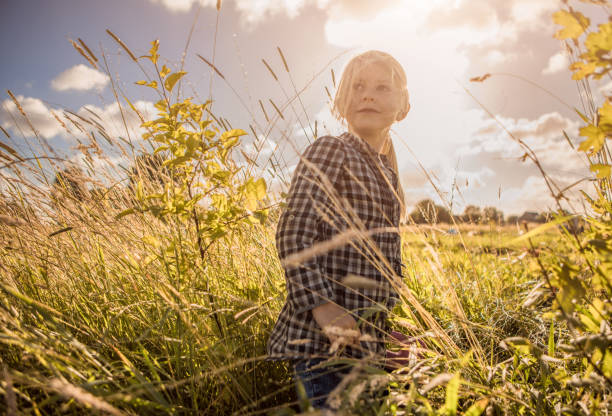 Rural, rural life. Walking through the meadow blonde young woman in a hat. Summertime.