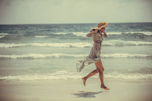 woman in a boho dress walking on the tropical beach