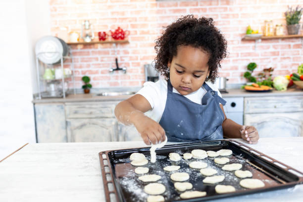istock Little girl making cookies at home 984043012