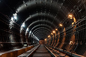 Straight circular subway tunnel with tubing and two different lights: white and yellow