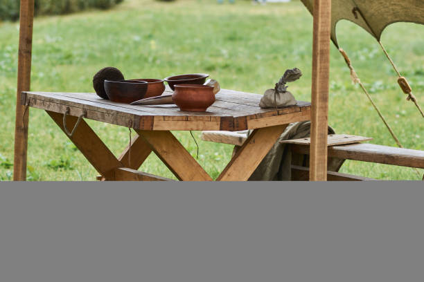 istock Medieval wooden utensils, placed on a large wooden table 984050860