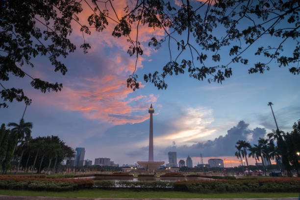 Indonesia National Monument in frame of the leaf during sunset picture of Indonesia National Monument in frame of the leaf during sunset with beautiful sky merdeka square stock pictures, royalty-free photos & images