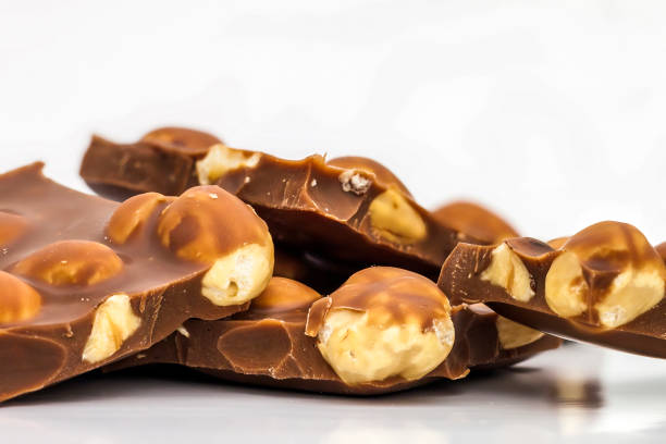 istock Milk chocolate pieces with whole hazelnuts. Chocolate bar / choc 984054648