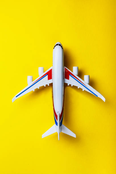 ミニマリズム。飛行機、ミニチュア、おもちゃ、黄色、背景します。飛行機での旅。旅、観光、上面図、コピー スペース - travel vacations studio shot vertical ストックフォトと画像