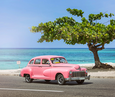 Vintage classic pink american oldtimer car near Havana Cuba at beach