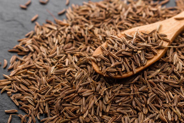 istock Seeds of cumin on a dark stone background 984065008