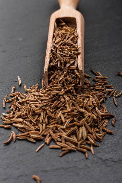 istock Seeds of cumin on a dark stone background 984065274
