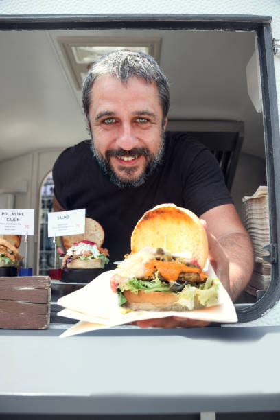 istock Food truck owner serving burger 984071434