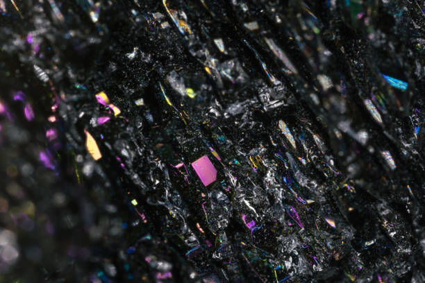 A rough chunk of skarn rock, composed of dark minerals, likely including garnet or pyroxene, mixed with white and yellowish crystalline inclusions. The specimen is unpolished and isolated on a clean white background.