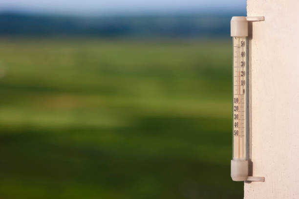 istock Thermometer celsius showing warm temperature on blurred green ba 984093180
