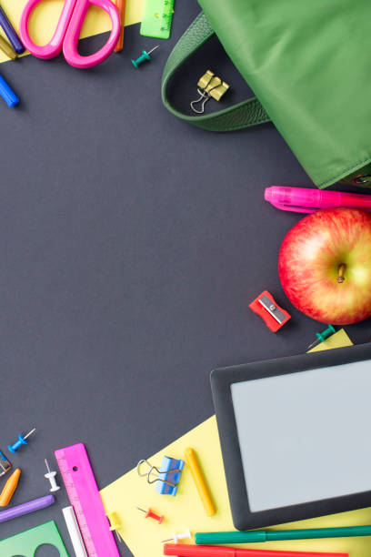 istock Concept back to school apple backpack stationery on black background. 984097242