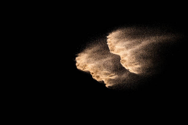 istock Abstract sand cloud. Golden colored sand splash agianst dark background. Yellow sand fly wave in the air. Sand explode on black background ,throwing freeze stop motion. 984102284