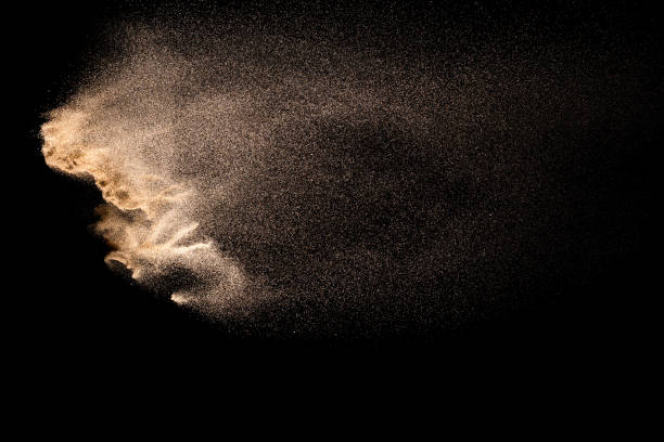 istock Abstract sand cloud. Golden colored sand splash agianst dark background. Yellow sand fly wave in the air. Sand explode on black background ,throwing freeze stop motion. 984102324