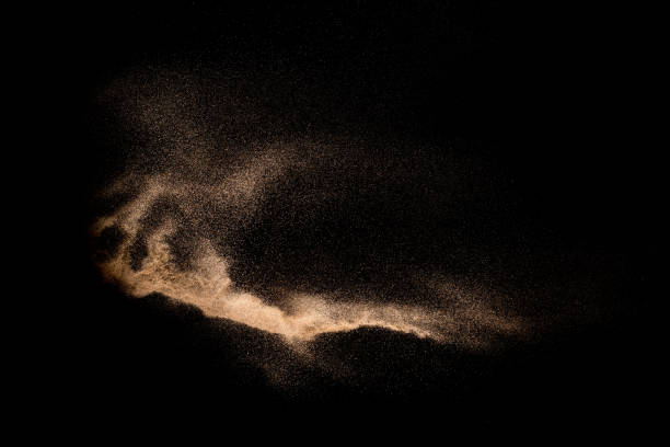 istock Abstract sand cloud. Golden colored sand splash agianst dark background. Yellow sand fly wave in the air. Sand explode on black background ,throwing freeze stop motion. 984102532