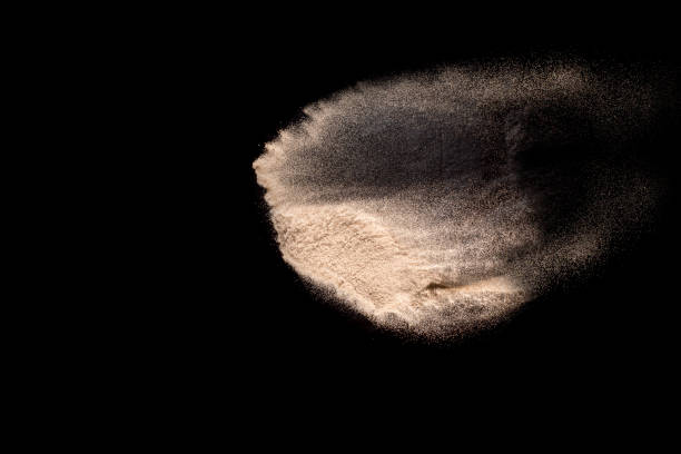 istock Abstract sand cloud. Golden colored sand splash agianst dark background. Yellow sand fly wave in the air. Sand explode on black background ,throwing freeze stop motion. 984102628