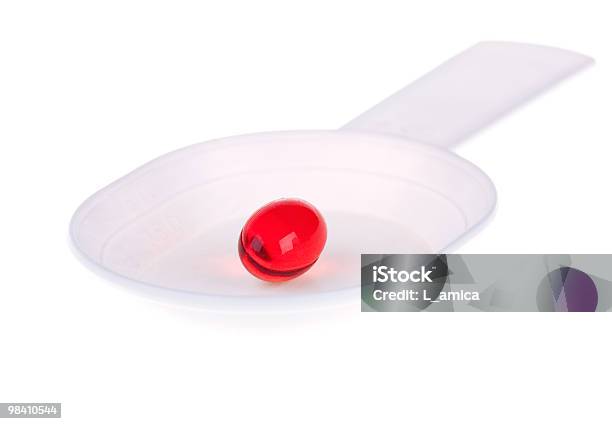 Rojo Cápsula En Una Cuchara De Plástico Blanco Foto de stock y más banco de imágenes de Antibiótico - Antibiótico, Asistencia sanitaria y medicina, Blanco - Color