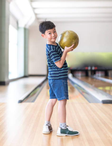 Portrait Cute child with ball in bowling club Portrait Cute child with ball in bowling club cricket bowler stock pictures, royalty-free photos & images