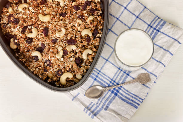 istock Granola on a baking sheet and yogurt on a light white background. 984112192