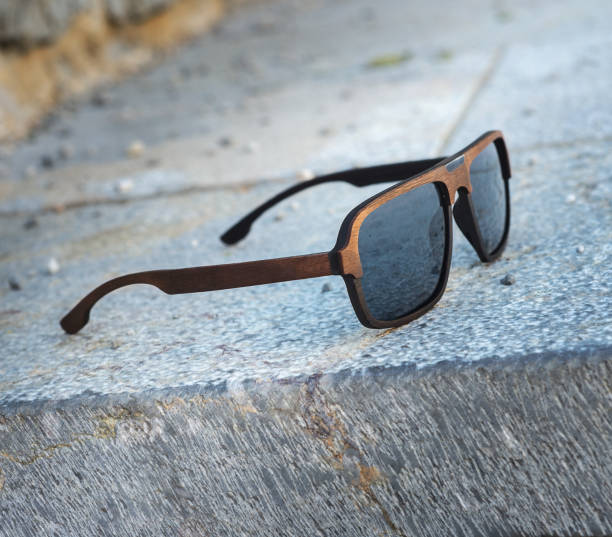 istock Sunglasses in a wooden frame on gray stone steps. 984126304